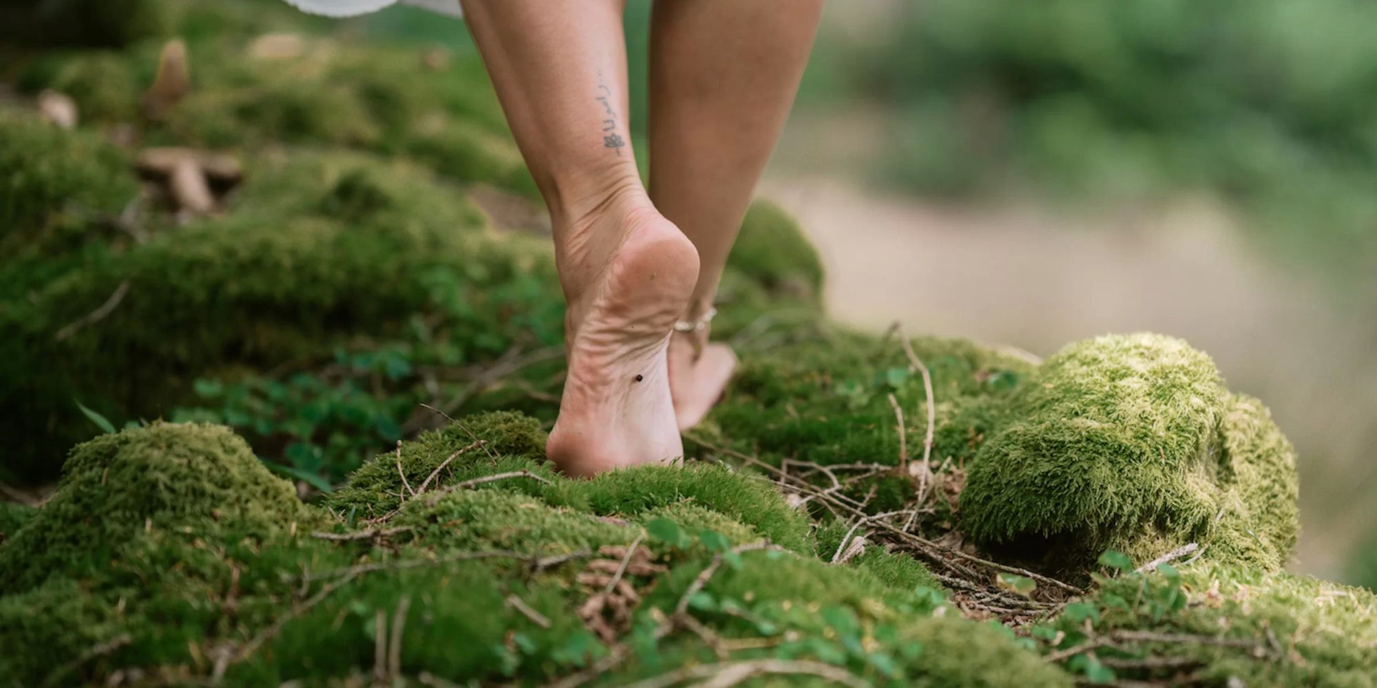 Barefoot walk through forest moss, female feet in close-up, enjoying nature and a grounding moment